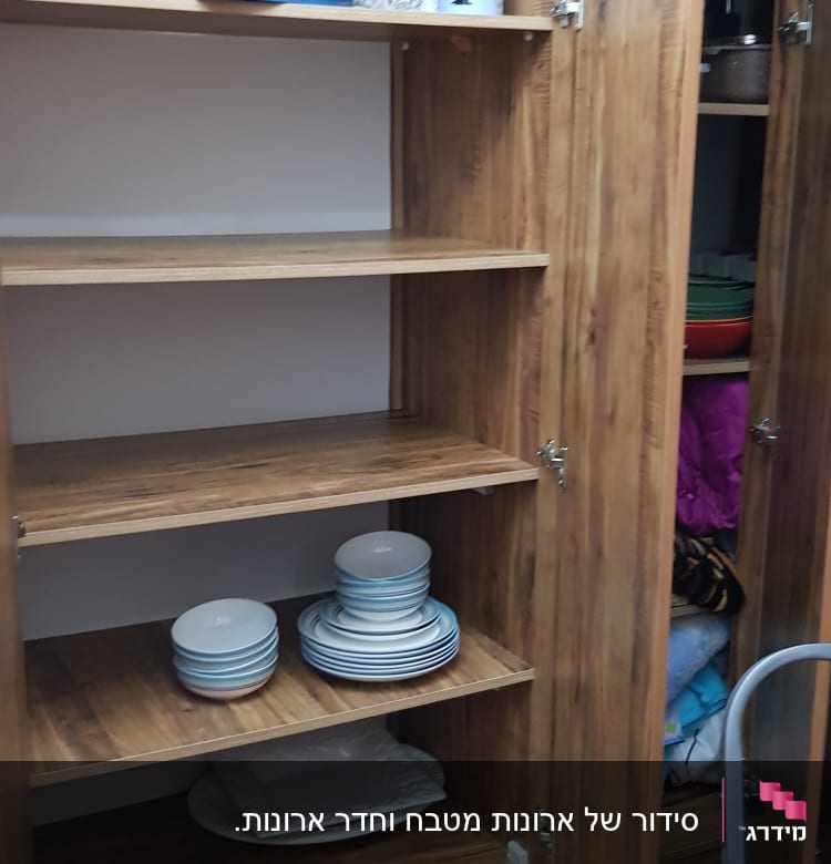 מדפים מעץ עם צלחות מסודרות בארון פתוח